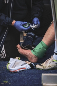 Person icing ankle after injury — foot fracture first aid in Frisco TX